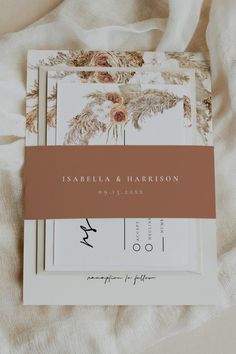 the wedding stationery is laid out on a bed