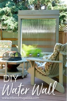 two chairs and a table on a deck with a grill in the back yard area