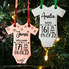 two baby's first christmas ornament hanging from a tree