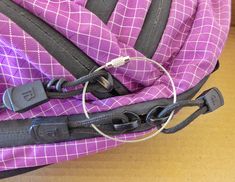 a close up of a purple and black piece of luggage on the ground with wires attached to it