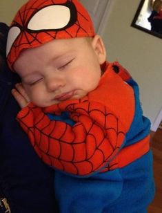 a baby wearing a spider man costume sleeping