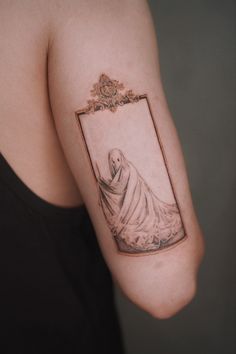 a woman's arm with a tattoo on it that has an image of a ghost