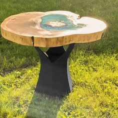 a wooden table sitting on top of a lush green field