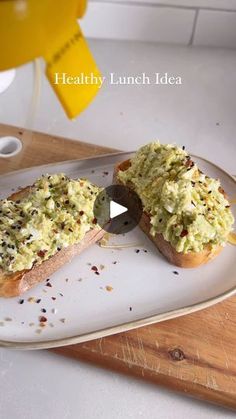 a white plate topped with two pieces of bread covered in green stuff and sprinkles