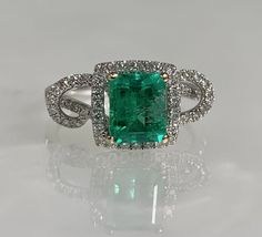 Square cut ring, emerald ring, emerald engagement ring, emerald ring for women, emerald diamond ring, 18k Emerald ring, 18K white gold ring A glowing modern emerald ring featuring a 1.27-carat emerald cut center stone accented by 0.42 carats of diamonds set in a solid 18k white gold twisted halo setting. *Ring size: US 6 3/4 *Ring weight: 4.30 Grams *Center stone dimensions: 7.5X6mm 14k White Gold Emerald Ring With Brilliant Cut, Green Diamond Cut Diamond Ring, Green Diamond Platinum Ring Fine Jewelry, Fine Jewelry Green Diamond Ring In Platinum, Fine Jewelry Green Diamond Platinum Ring, Green Platinum Diamond Ring, Emerald Ring With Halo Setting In Platinum, Green Emerald Ring With Diamond Accents In Platinum, Green Emerald Ring With Halo Setting In Platinum