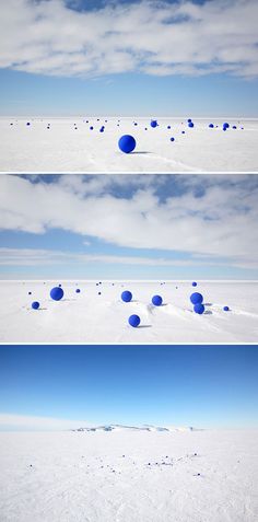 blue balls are floating in the air above snow covered ground and on top of each other