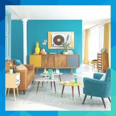 a living room with blue walls and yellow accents on the furniture in front of it