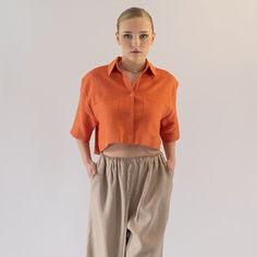 This cropped shirt is designed with a classic shirt collar and box pleat at the back for extra volume. Oversize pockets add expressiveness to the silhouette. This piece of heaven of a shirt  is a high quality hand made work and perfect for well your body for extra chic in your style. This piece of a shirt won't take too long to become a staple piece of your wardrobe, perfect for various stylings and occasions, you will feel light and relaxed anywhere you go! This garment is made of finest qualit Casual Cropped Blouse With Pockets, Cropped Linen Workwear Tops, Classic Collared Cropped Shirt With Pockets, Orange Workwear Top With Pockets, Classic Short Sleeve Cropped Shirt For Work, Classic Cropped Short Sleeve Shirt For Work, Solid Cropped Shirt For Spring, Spring Cropped Shirt With Pockets, Solid Color Cropped Shirt For Spring