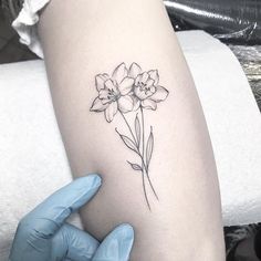 a person holding their arm with a flower tattoo on it