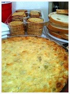 there is a cheese pie on the table next to other pastries and breads