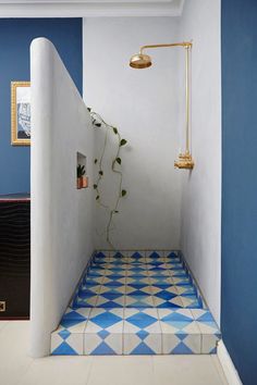 a blue and white tiled bathroom with an open shower