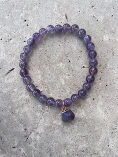 Amethyst is a violet semi-precious gemstone with metaphysical properties.  This purple crystal inspires healing and an enhances meditation.  It's high frequency purifies the aura of any negative energy or attachments.   It creates a shield of light around the body for added protection.  Amethyst is associated with the Third Eye, Crown and Etheric Chakras.  This bracelet would make a meaningful accessory for you or loved one. The Lava bracelet is sold separately and you can find it here:  https://www.etsy.com/shop/FamilyandFairytales?ref=shop-header-name&listing_id=1597013567&from_page=listing§ion_id=45744945 + Details: We used an Amethyst charm surrounded by 6mm Amethyst beads on a stretch cord. + Custom Requests:  We welcome your requests!  Please send us a detailed message of what you ar Yoga Tools, Lava Bracelet, Amethyst Bracelet, Crown Chakra, Amethyst Beads, Purple Crystals, February Birth Stone, Third Eye, Semi Precious Gemstones