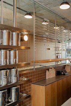 the interior of a restaurant with stainless steel pots and pans on shelves in front of them