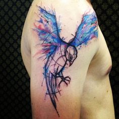 the back of a man's shoulder with an artistic tattoo design on his arm