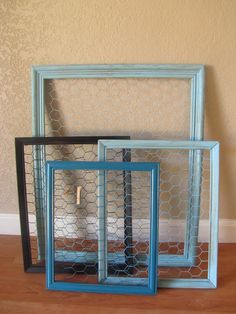 three frames with chicken wire in them on the floor