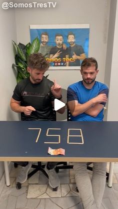 two men sitting at a table with the number 788 written on it in gold