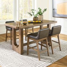 a dining room table with chairs and fruit on it