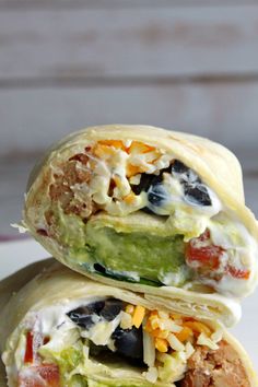 two burritos stacked on top of each other with different toppings in them