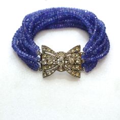 "A collection of very fine quality gemstones, these are sparkling tanzanite micro faceted gems with glittery shine and beautiful drape. The impressive nine strands are highlighted by a gorgeous vintage rhinestone box clasp to dress the inner or outer wrist and secures at 7.25\" long. When worn the strands all lay obediently side by side, not clustered as in the photos. The sparkle and flash that comes off of this tanzanite is glorious and utterly glamorous and this bracelet is sure to become a f Tahitian Pearl Pendant, Tanzanite Bracelet, Tanzanite Jewelry, Faceted Gems, Box Clasp, Bracelet Vintage, Strand Bracelet, Statement Bracelet, Silver Rhinestone