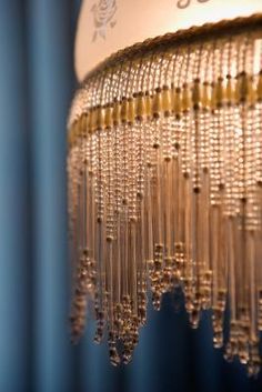 a chandelier hanging from the ceiling in front of a blue wall and window