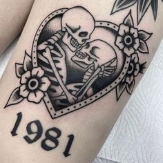 a tattoo with a skull and flowers in the shape of a heart