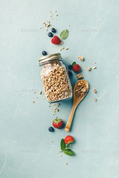 granola in a glass jar with strawberries and blueberries on the side - stock photo - images