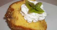 a piece of cake with whipped cream and mint on top is sitting on a white plate