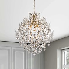 a chandelier hanging from the ceiling in a room with white walls and windows