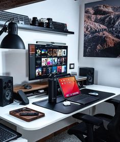 a laptop computer sitting on top of a desk next to speakers and a desktop computer