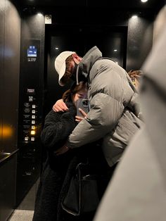 a man and woman hugging in an elevator