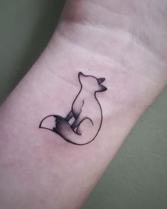 a small fox tattoo on the wrist