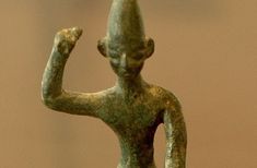 an ancient statue holding a bird in its hand