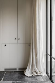 a white curtain hanging from the side of a closet