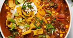 a white bowl filled with chili and tortilla soup