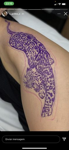 a tattoo on the arm of a woman with a purple leopard design on her shoulder