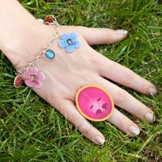 a woman's hand with flowers on it and a pink button attached to the wrist