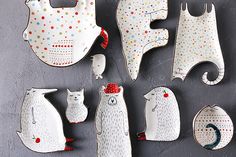 several ceramic animals are arranged on a table top, one is white and the other is red