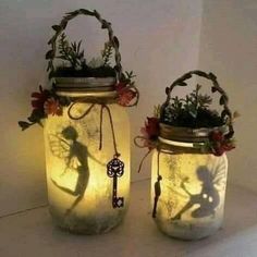 two mason jars with plants in them sitting on a table next to each other and the shadow of a person holding a key