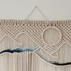 a crocheted wall hanging with waves and mountains on the side, made from yarn