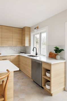 a kitchen with white counter tops and wooden cabinets, along with a dishwasher