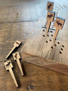 three wooden pegs with moose designs on them