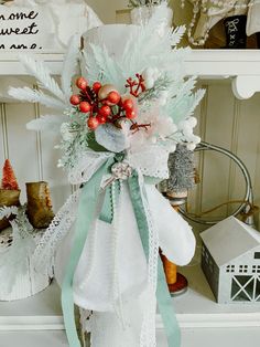 a white vase filled with lots of flowers on top of a shelf next to other items