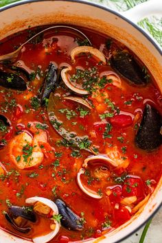 a pot filled with seafood and mussels on top of a table