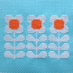 a cross stitch pattern with three orange flowers