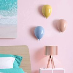 a bedroom with pink walls and pastel colored balloons on the wall above the bed