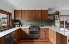 a kitchen with wooden cabinets and white counter tops, along with a stainless steel stove top oven