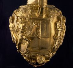 an ornate gold vase with figures on it