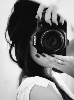 a woman taking a selfie with her camera in front of her face and hands