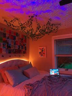 a bed room with a laptop computer on it's side under a purple light