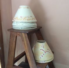 a wooden stand with three different colored vases on it's top and bottom